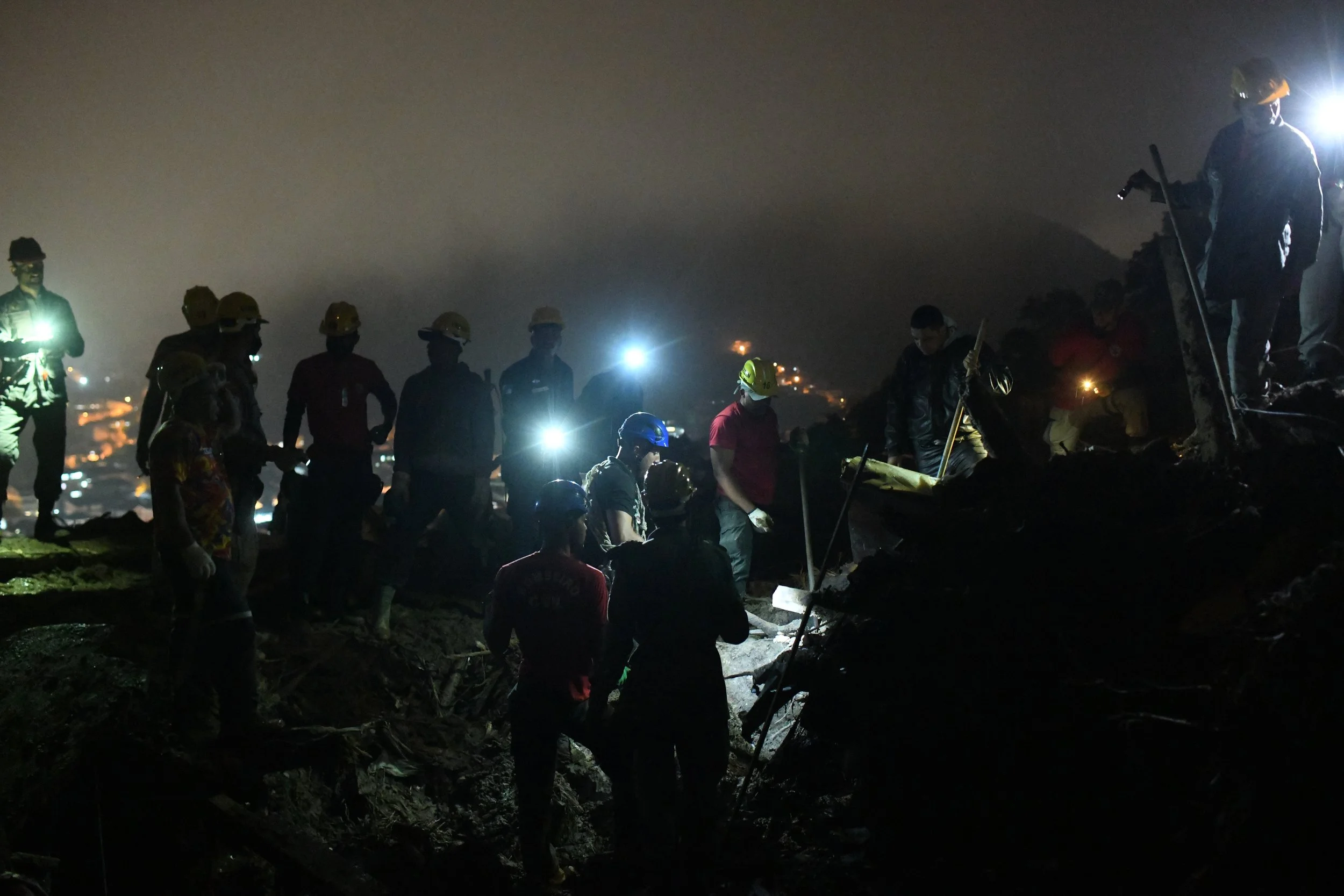  Um grupo de bombeiros militares e voluntários se mobiliza no resgate de corpos no Morro da Oficina. Eles chegaram na local quando já era noite de sexta. 18 Fev, 2022. 