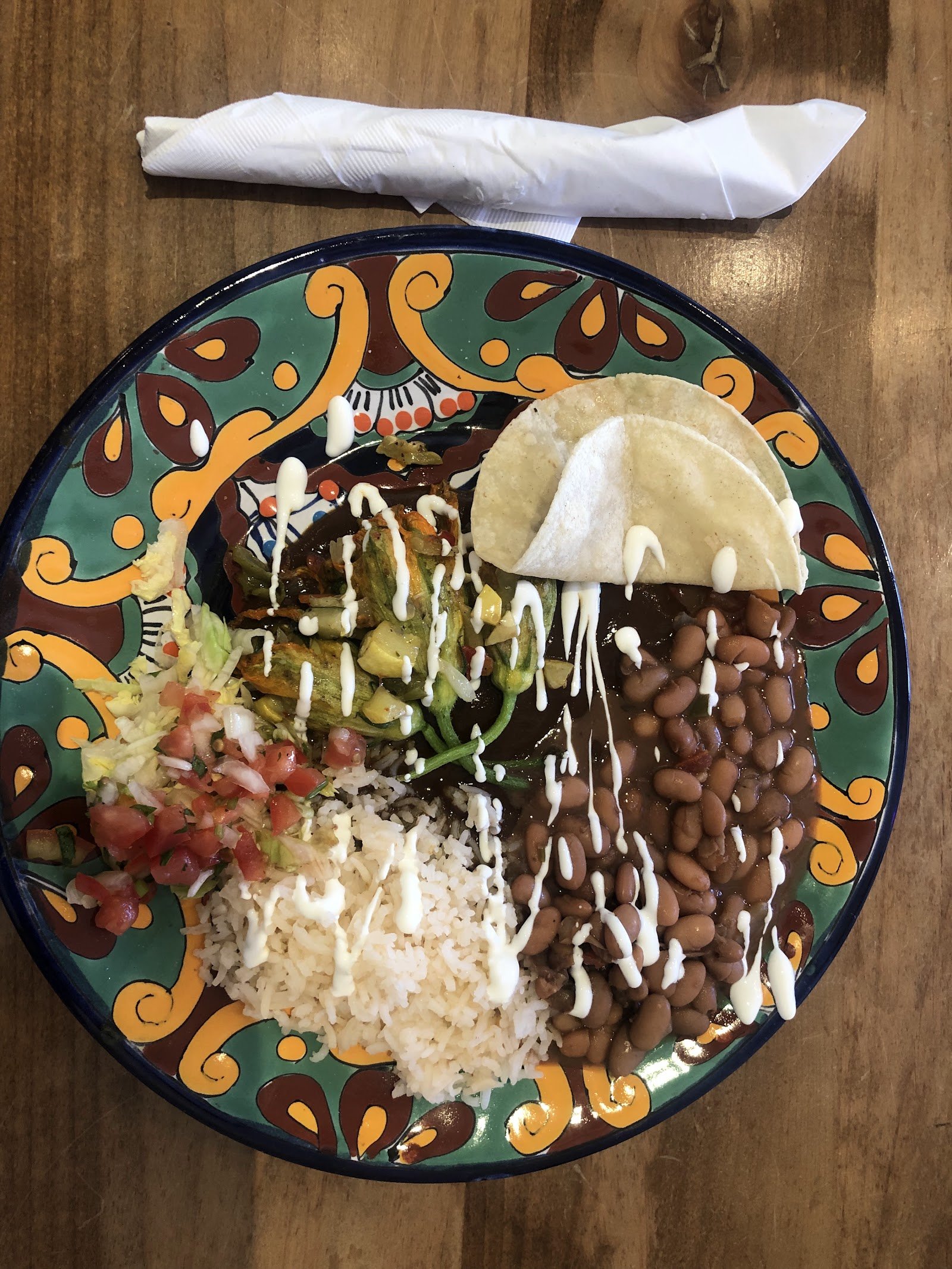 Plate of New Mexican food smothered in chile with beans, rice, and a warm tortilla in Santa Fe