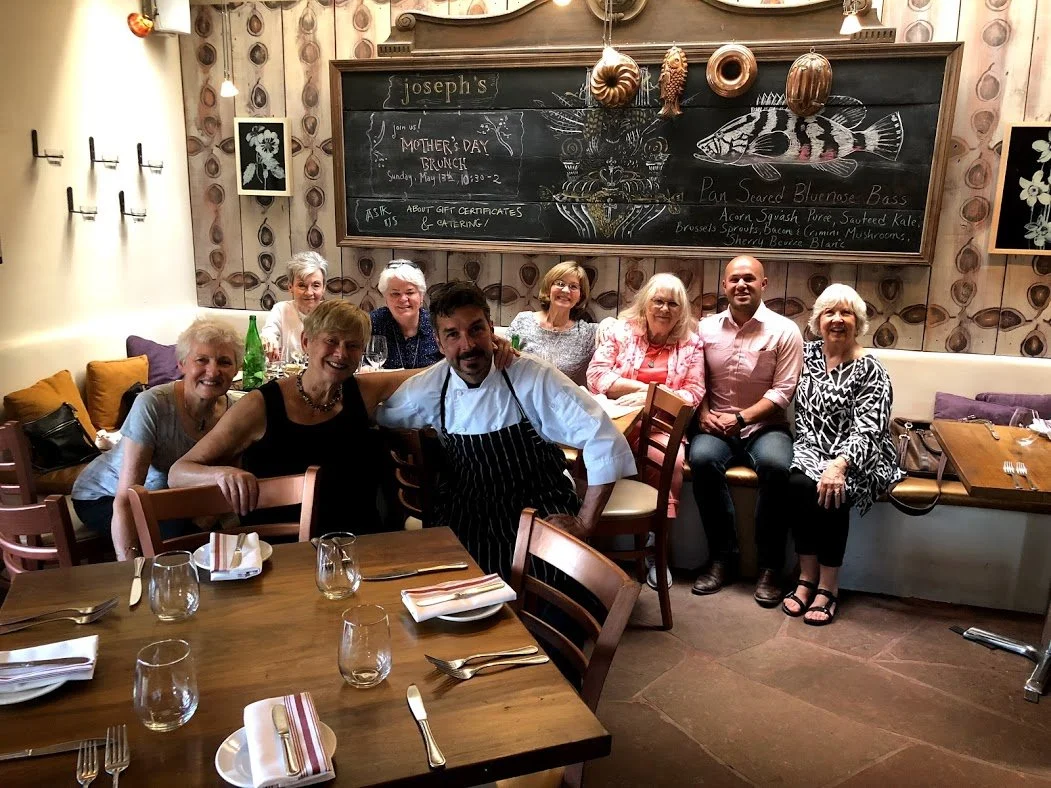 Wander New Mexico chef-guide with a happy food tour group at a Santa Fe restaurant