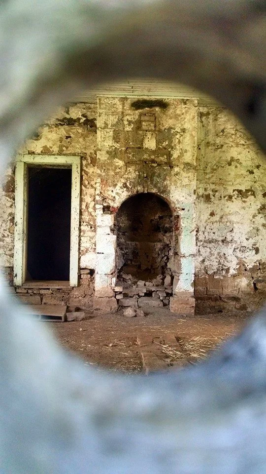 View of inside one of the locked buildings through a hole in the door.