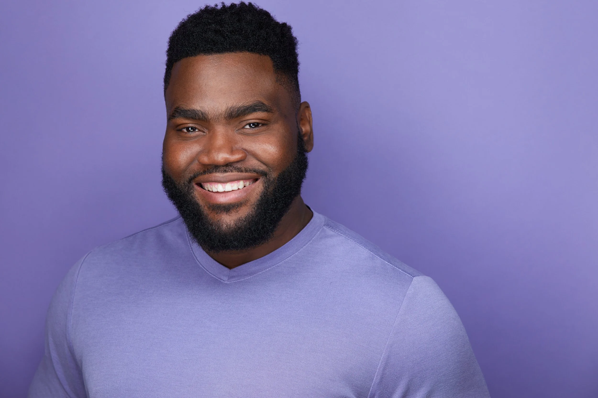 Femi Sobaki Headshot on light purple backdrop in Ryan Parker Photography Studio in Edmonton.