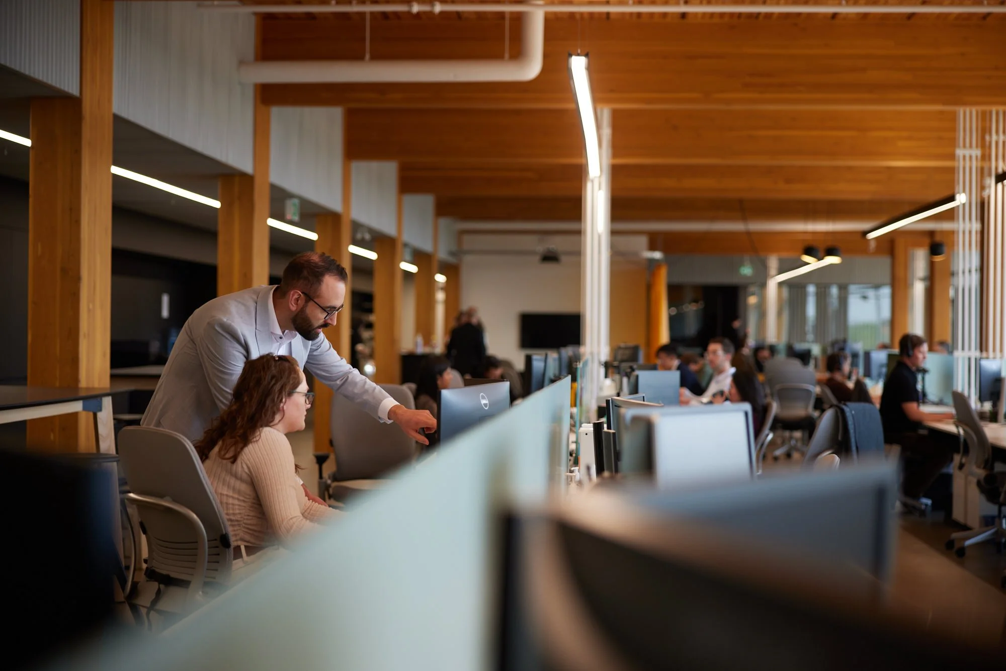 Candid workplace photo of colleagues collaborating at their desks, Edmonton office photography