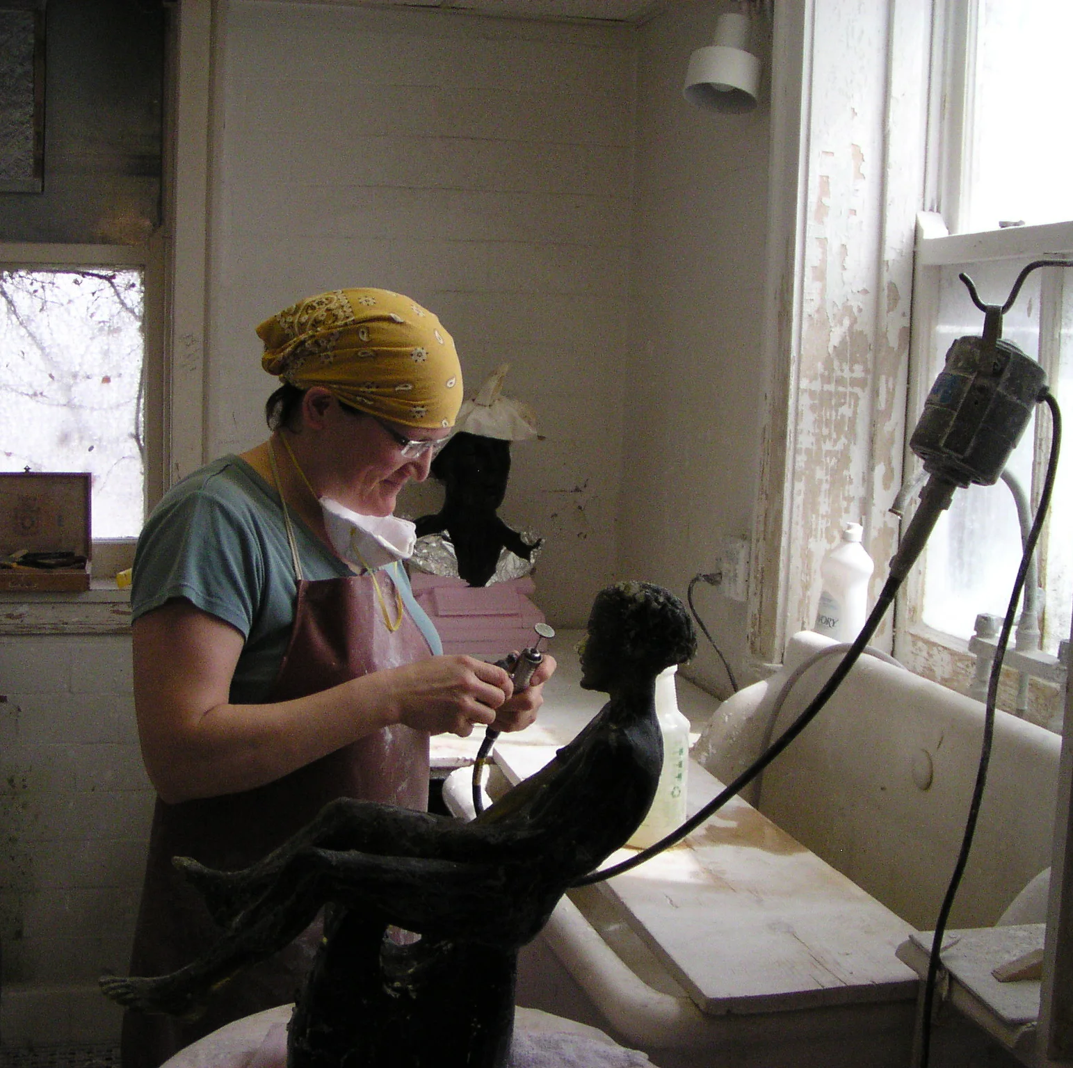 Melanie Hunter cold-working a nearly opaque glass piece in the studio.