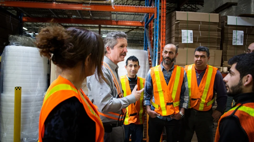 Estill speaking to employees at his company warehouse (Annie Sakkab / UNHCR)