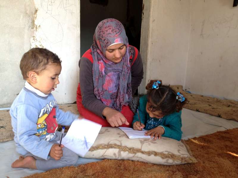  Bushra in a refugee camp in Lebanon with her children (E. Byun / UNHCR) 