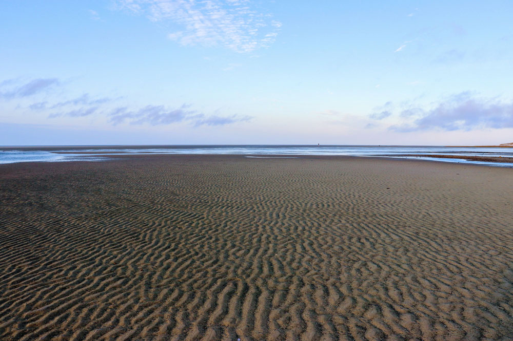 The water you can see is just a tidal pool. Then, there's more sand. The actual ocean is the last line of dark blue before the sky begins. In this photo, we're about 1/2 way out. I can't put it in words... you have to experience it for yourself. 