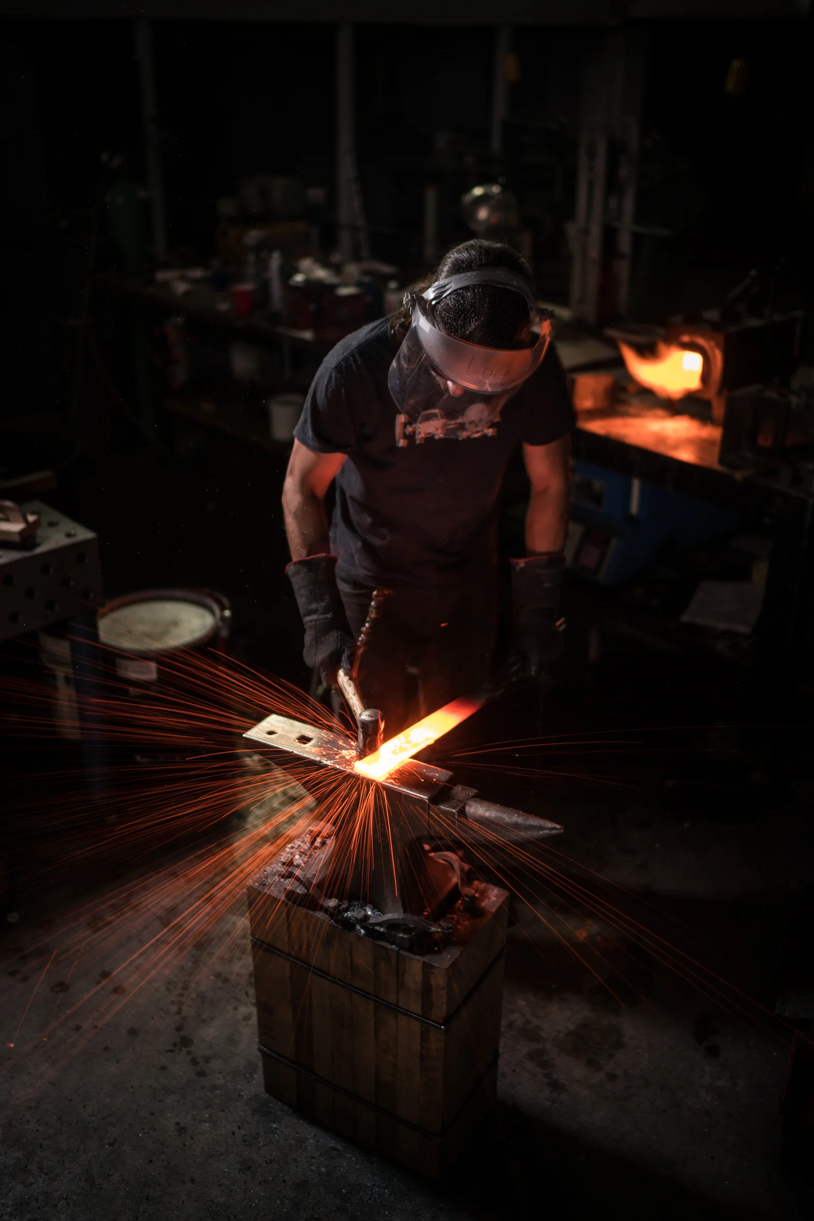 Here, Lock is striking a piece of damascus steel in the early stages of forging.
