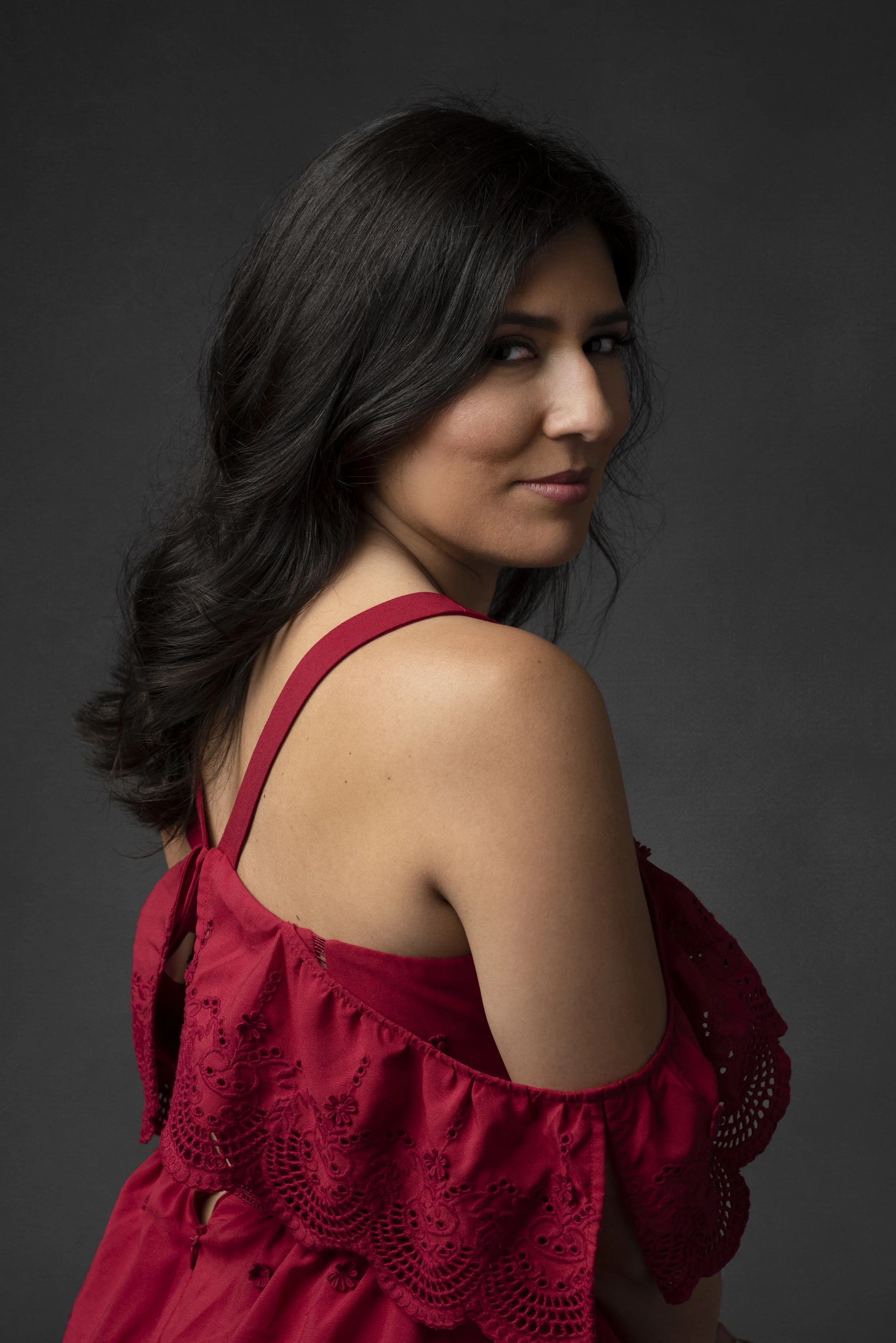Studio portrait of woman wearing red Spanish style dress.