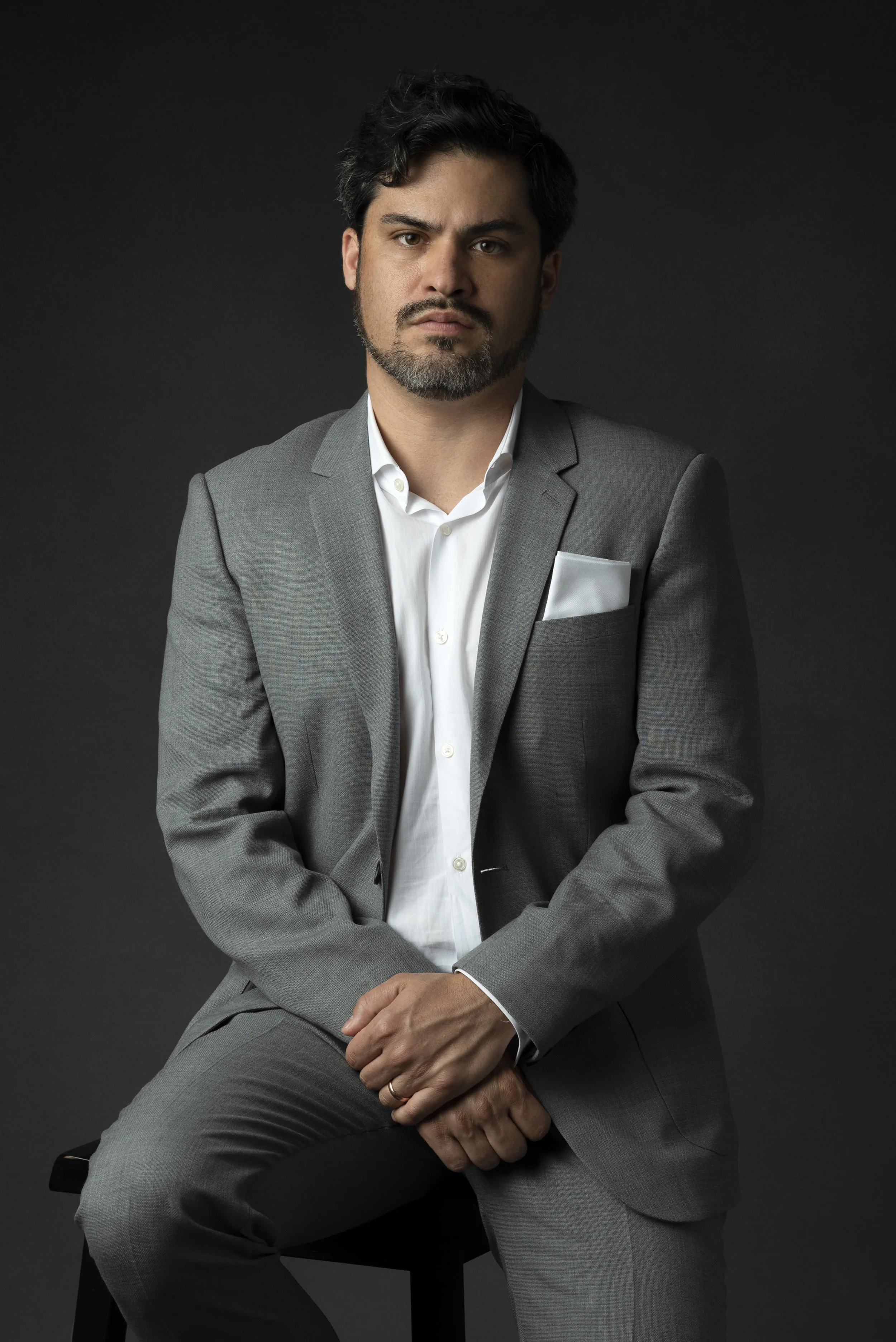 Studio portrait of man in gray suit on gray background
