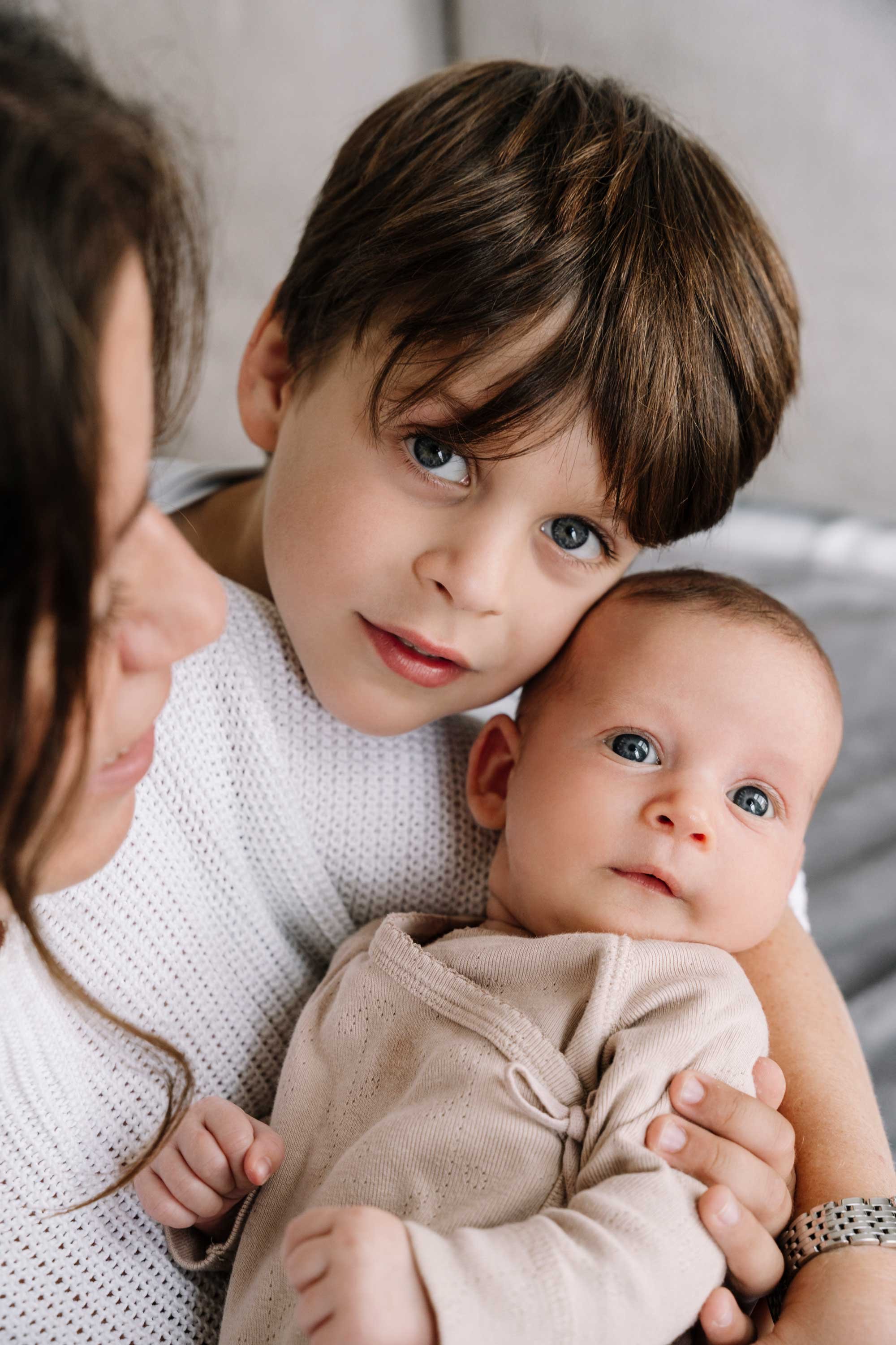 A photo of a big brother and newborn sister together.