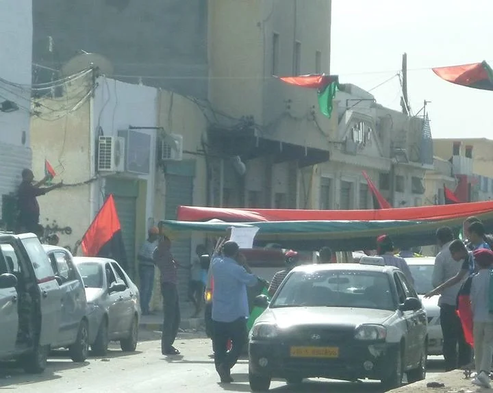 A large Libyan flag stretched across the street — Tripoli, 20 October 2011