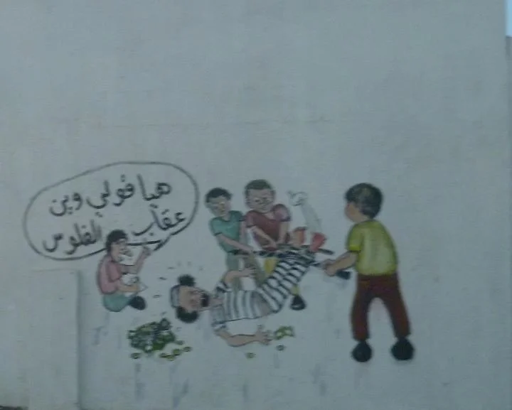 Cartoon mural on a street wall — Tripoli, 20 October 2011