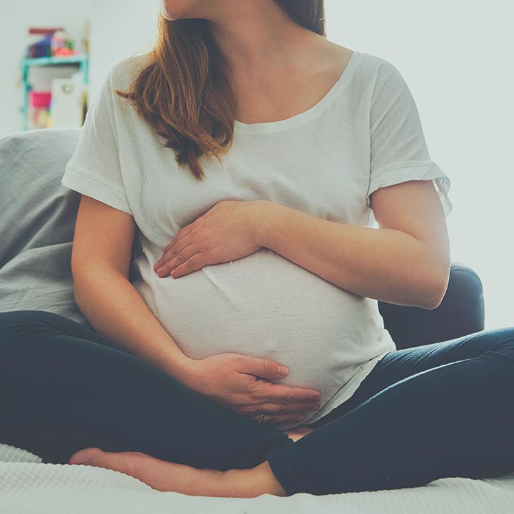 Pregnant woman holding her belly at a wellness appointment