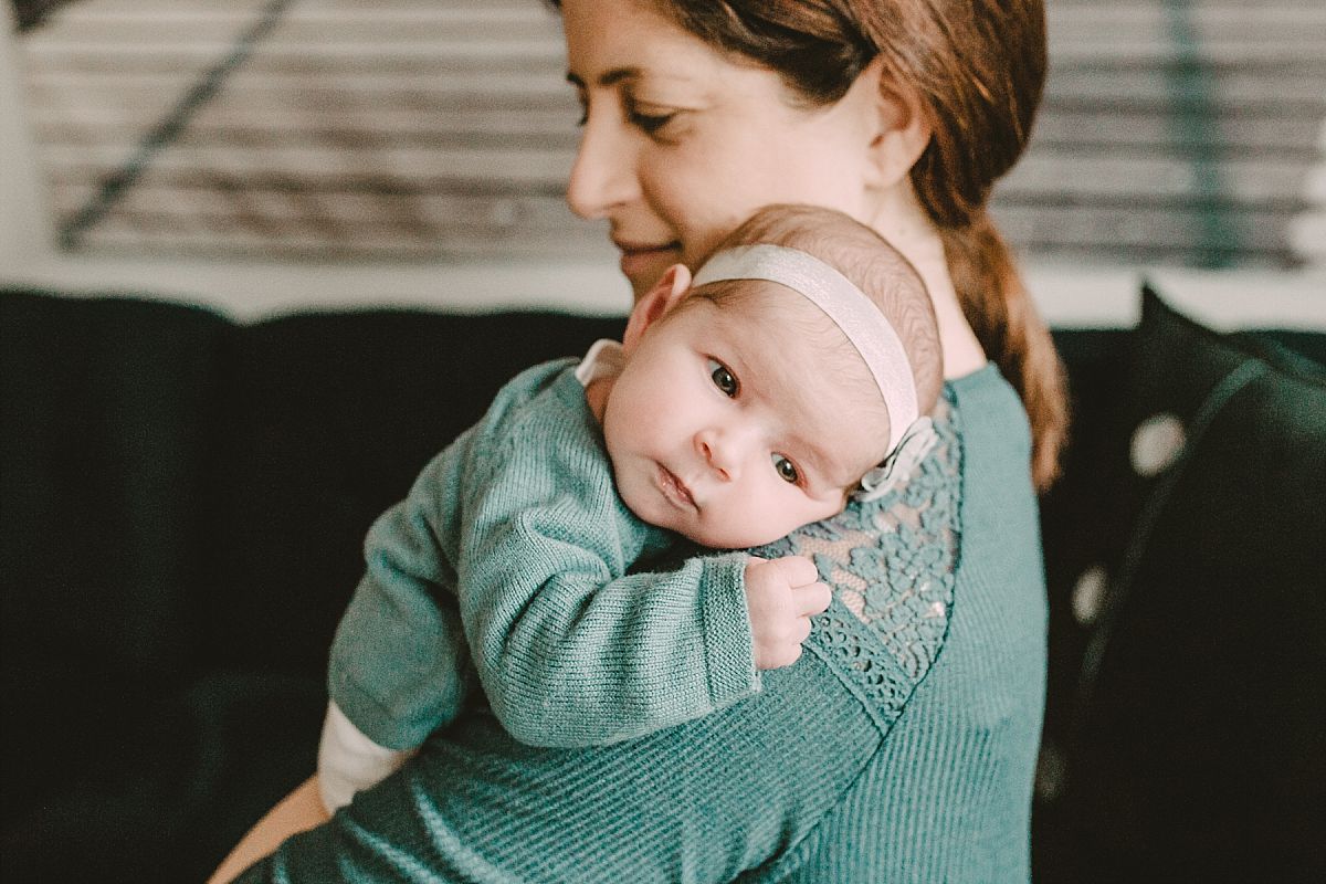 nyc family and newborn photographer newborn hanging over mom's shoulder