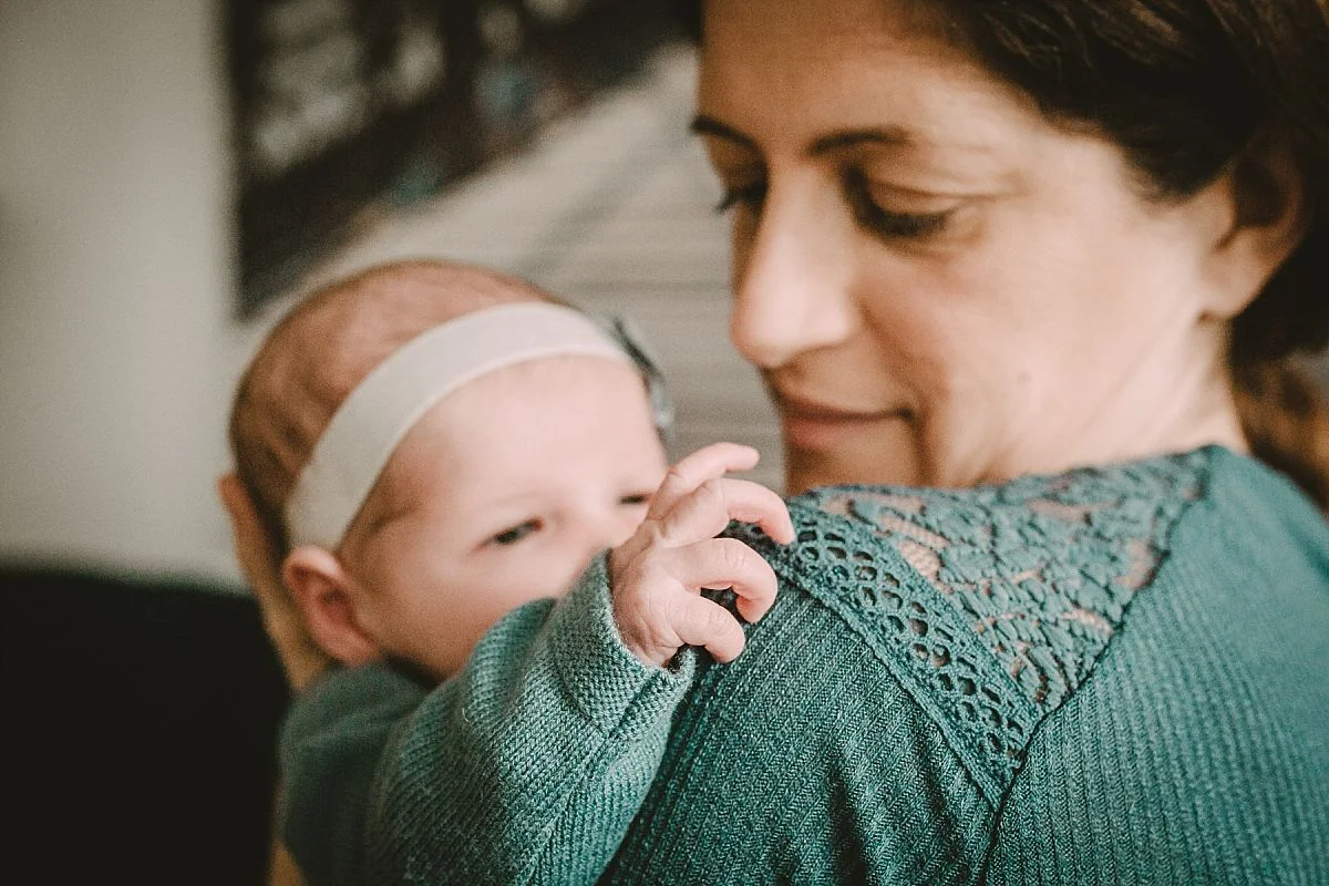 nyc family and newborn photographer newborn playing with mom's lace top