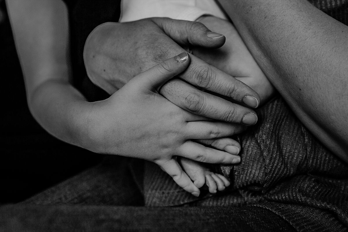 nyc family and newborn photographer hands of mom, big sister and newborn