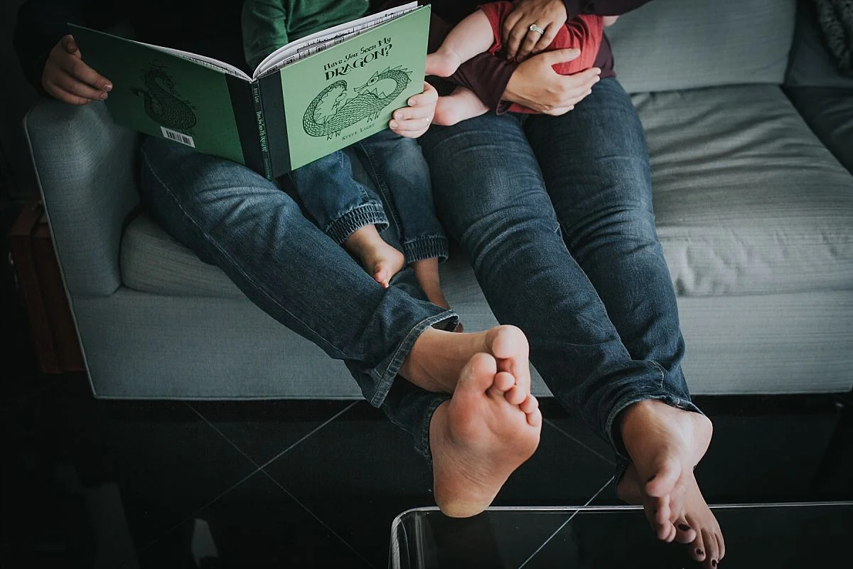 nyc family and newborn photographer family of four read in living room and feet photo