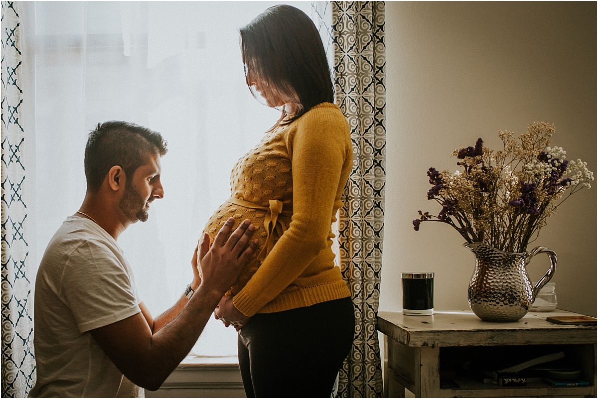nyc family and newborn photographer expecting dad holds beautiful baby bump for in home maternity session