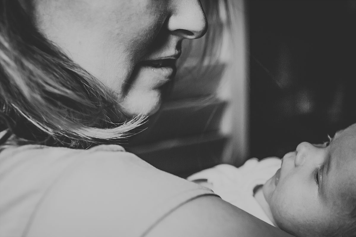 nyc family and newborn photographer close up of new mom holding newborn baby girl in Chelsea abode