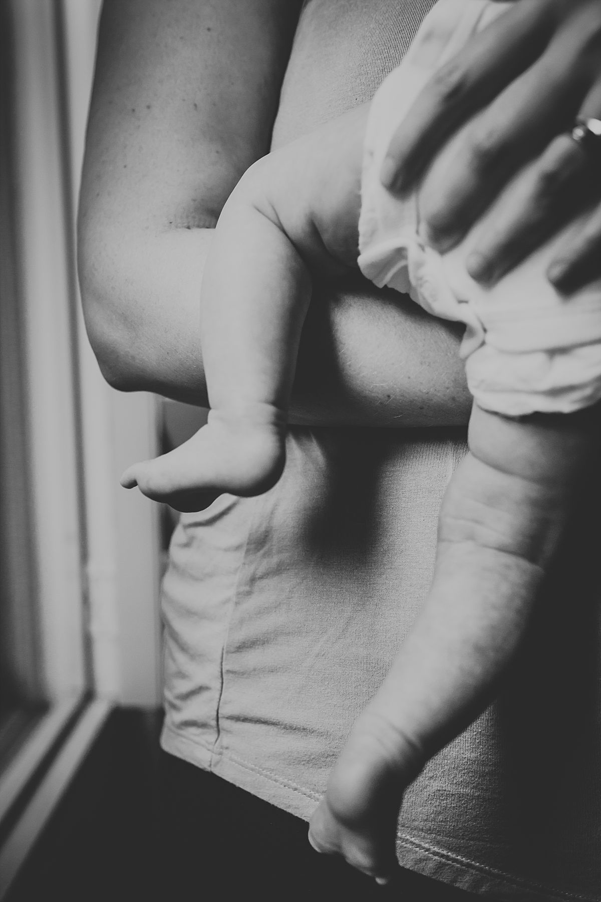 nyc family and newborn photographer close up of dangling baby feet near window