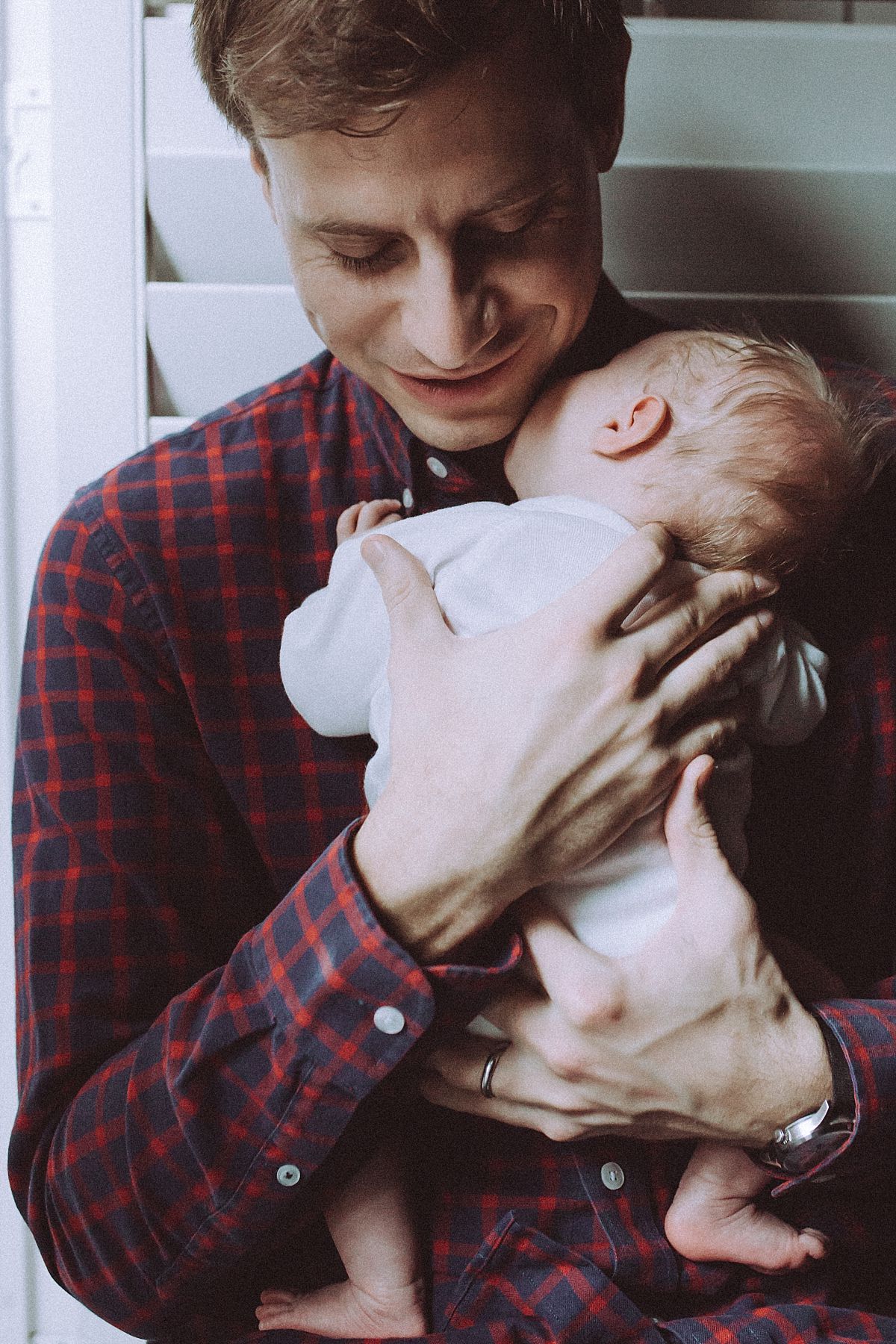 nyc family and newborn photographer dad holds newborn baby girl in Chelsea abode