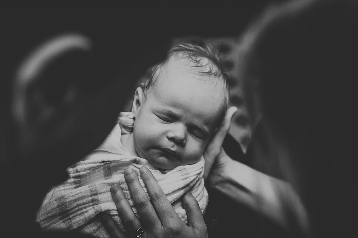 nyc family and newborn photographer newborn baby girl looking over mom and dad's shoulders