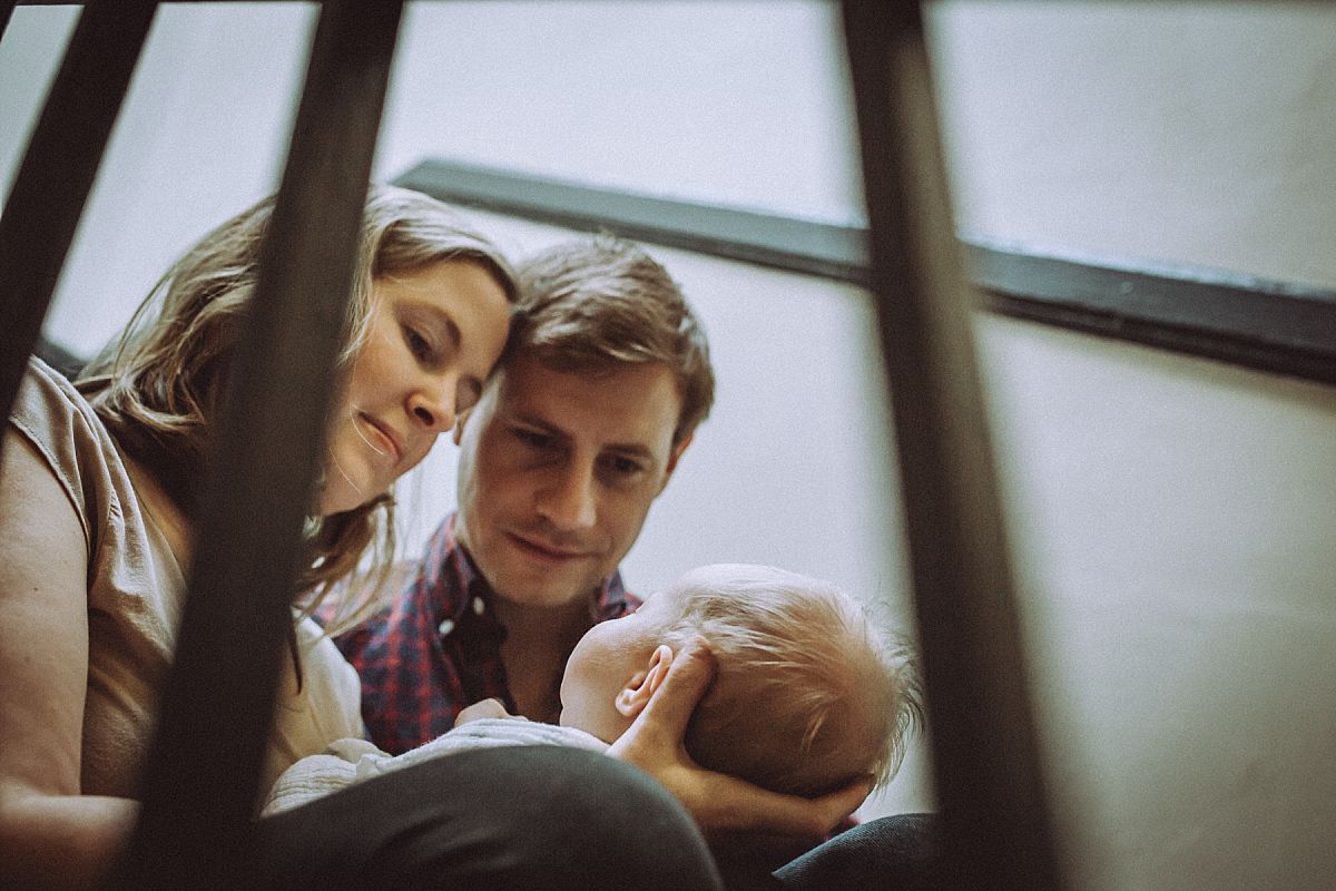 nyc family and newborn photographer mom, dad and newborn baby girl in stairwell in Chelsea apartment block