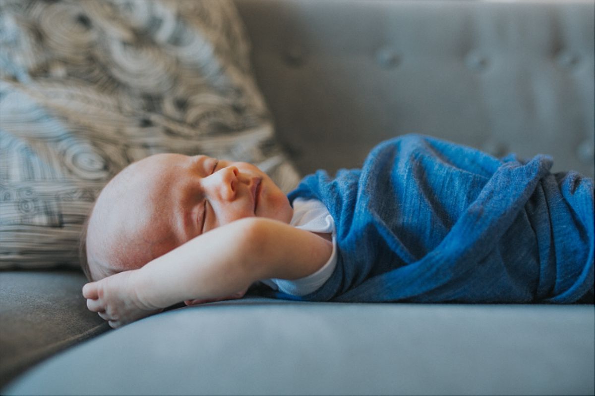 nyc family and newborn photographer newborn son sleeps on couch of upper west side apartment