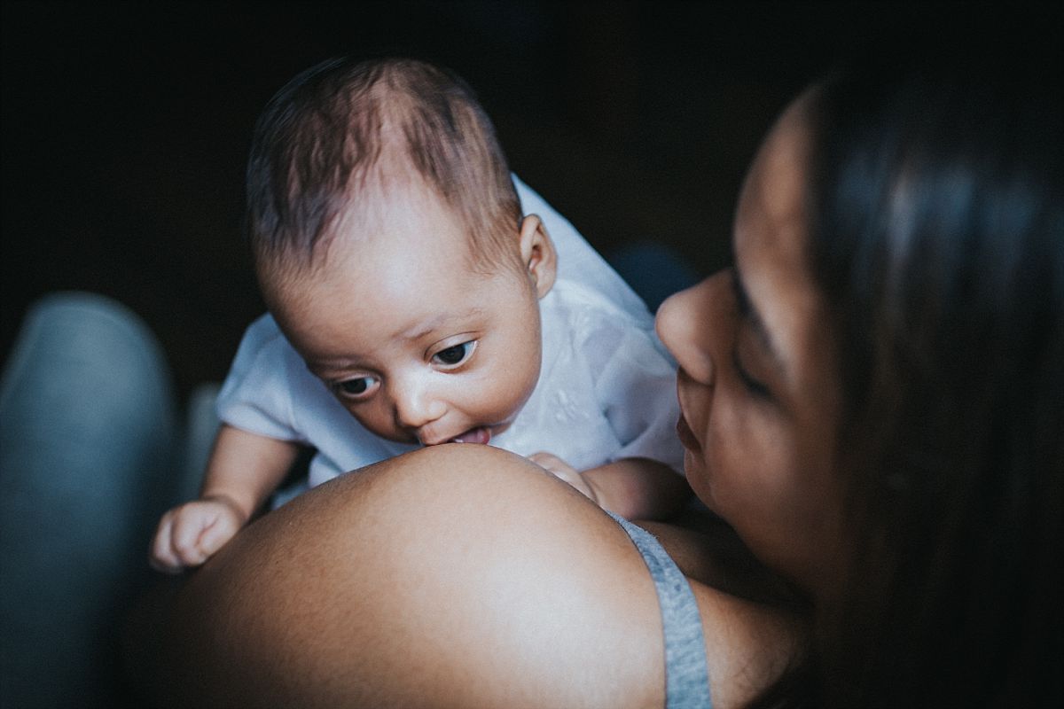 nyc family and newborn photographer newborn girl lifts head up on on mom's shoulder in mommy and me session