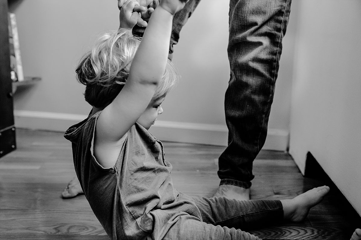 nyc family and newborn photographer dad playing with toddler trying to lift him up off the ground