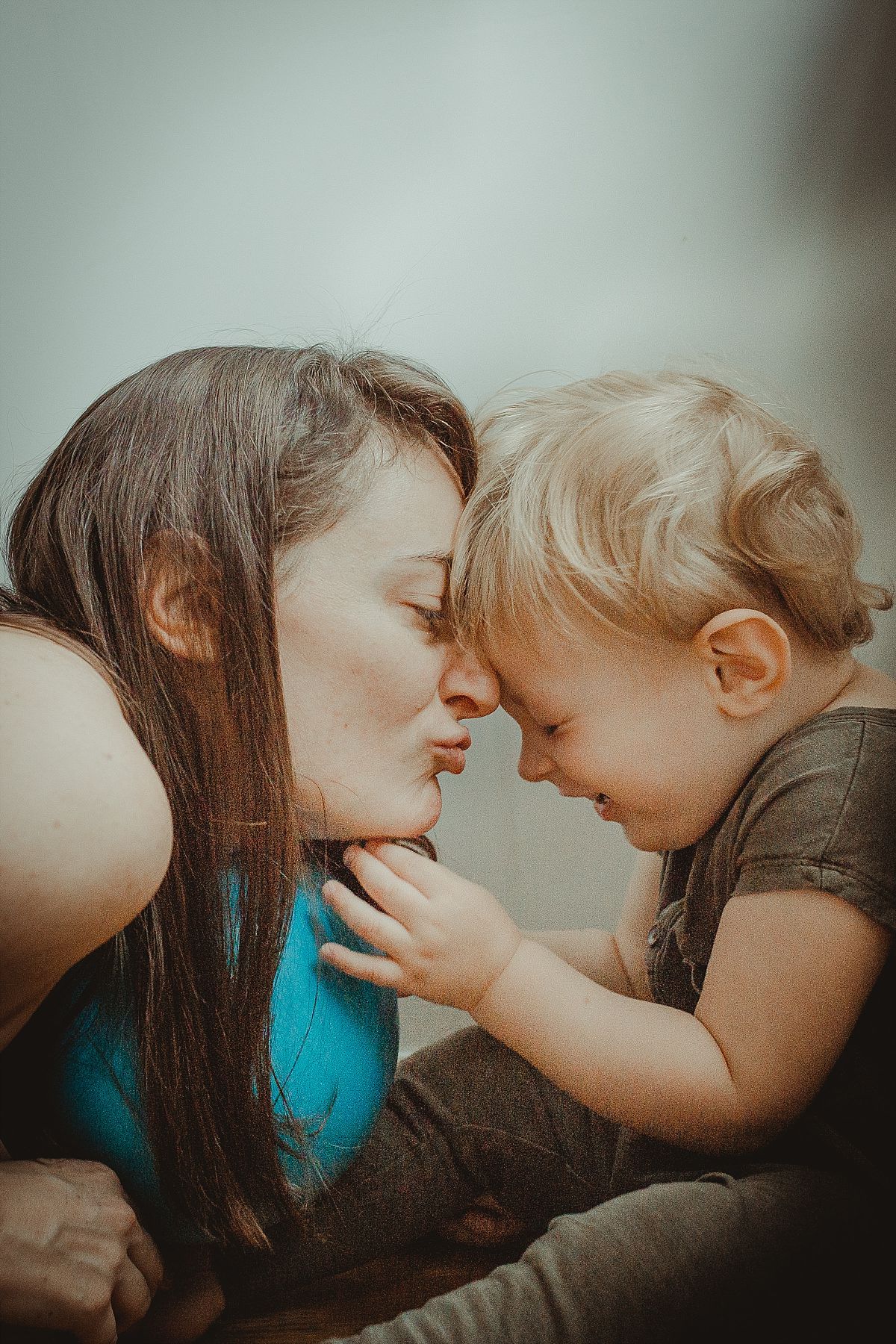 nyc family and newborn photographer mom tries to kiss son while son giggles