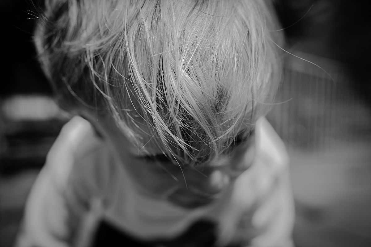 nyc family and newborn photographer son plays at park and his gorgeous blonde hair shines in the light