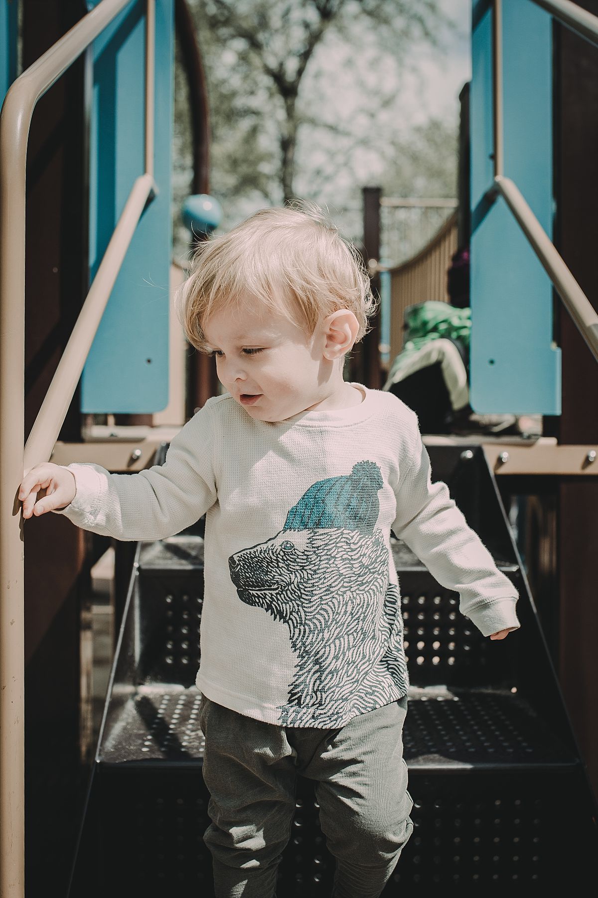 nyc family and newborn photographer boy going down stairs at new york playground