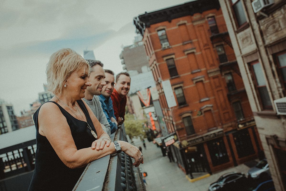 mom with three sons leaning over railing and looking at road at the high line in nyc by Krystil McDowall photography