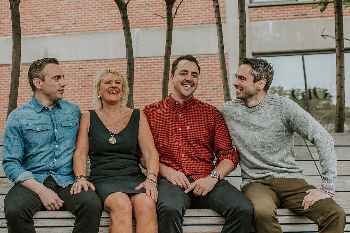 mom and three sons on park bench at the highline having a chat and a laugh during nyc family photo session