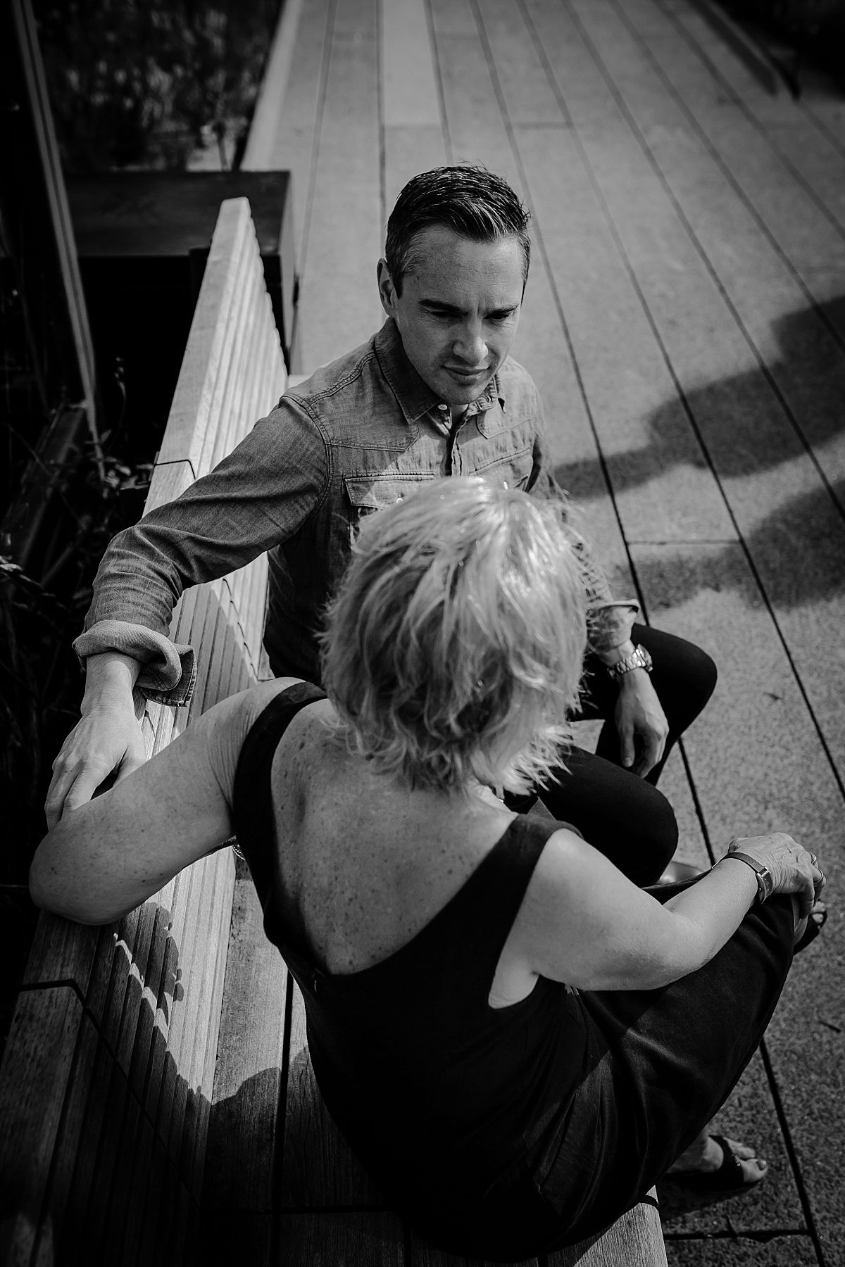 mom and handsome sitting on the highline park bench having a chat. photo taken from birds eye view during family photo session