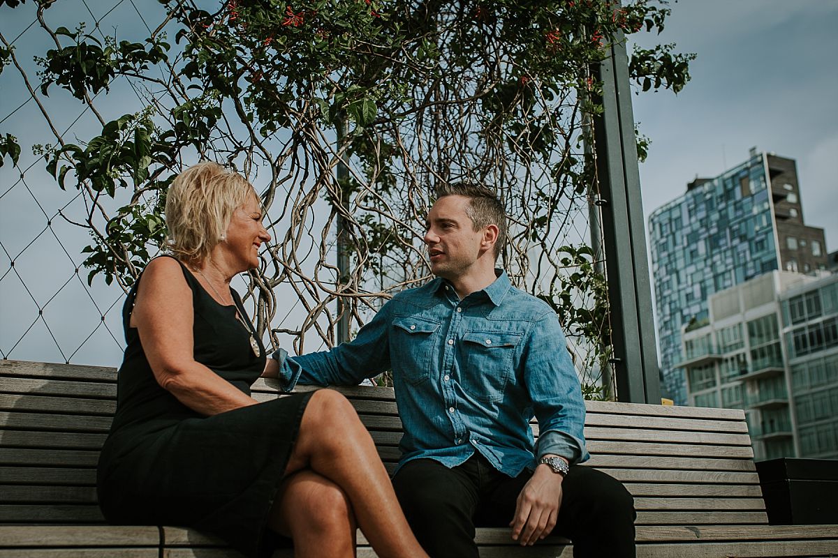 mom with handsome son sitting on beautiful park bench on a sunny morning at the highline