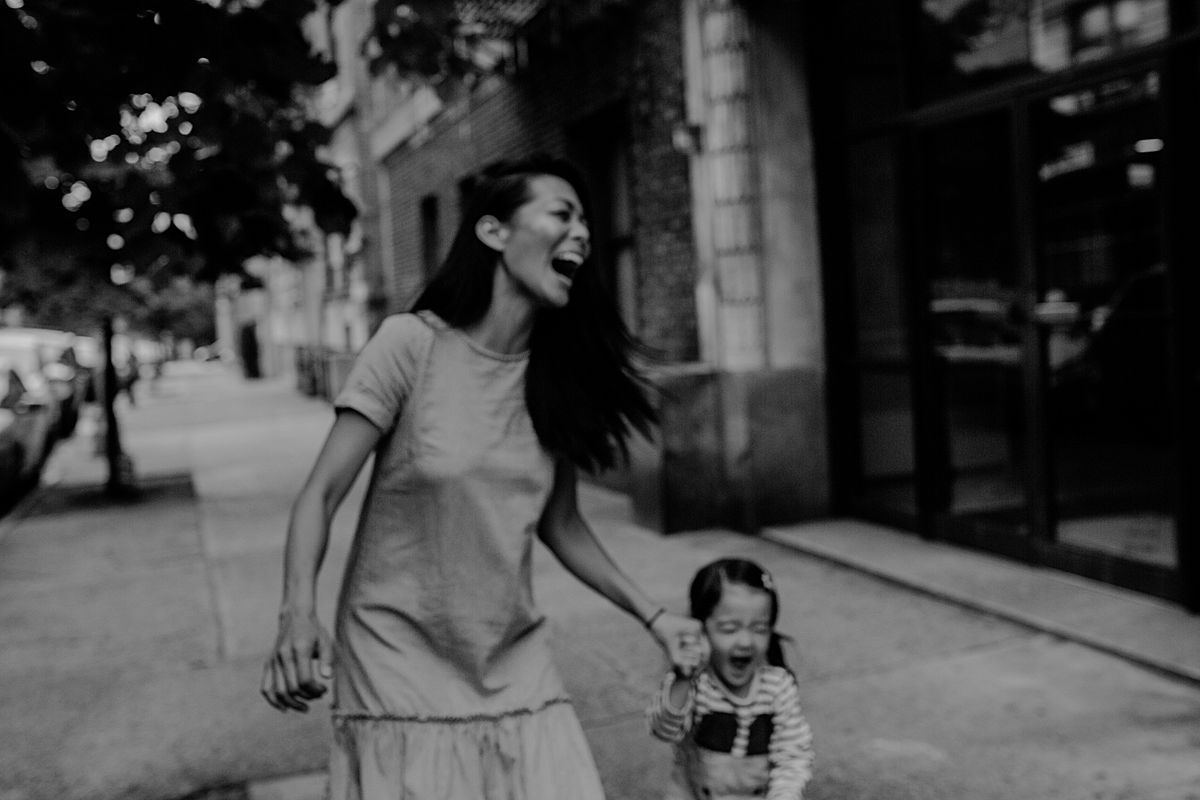 the hugest laughs from mom and daughter while in nyc sidewalk. photo by nyc family photographer