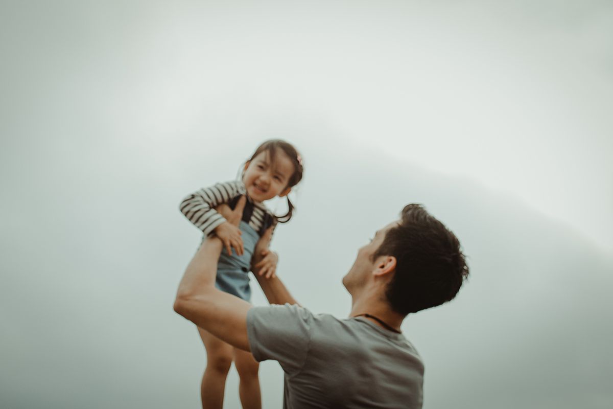 Dad holding daughter in the air. photo taken by nyc family and newborn photographer