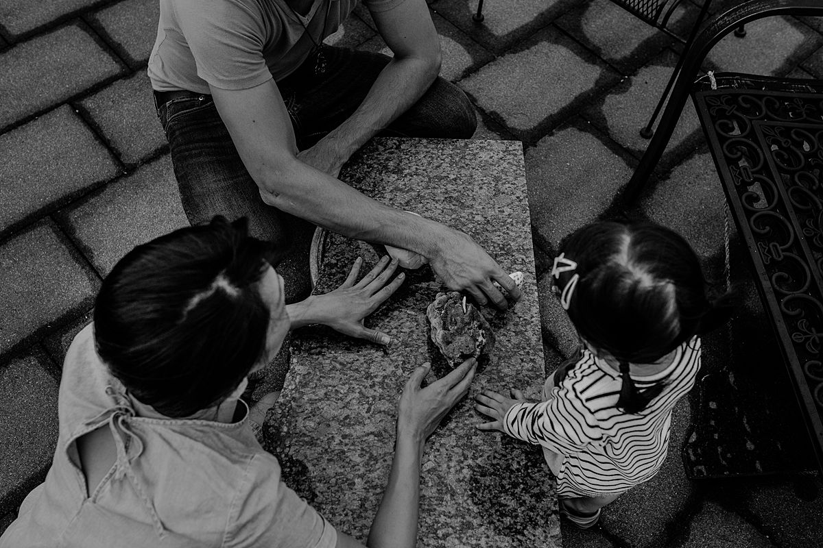daughter, mom and dad explore beach coral. photo taken from a birds eye view. photo taken by krystil mcdowall during documentary nyc family photoshoot