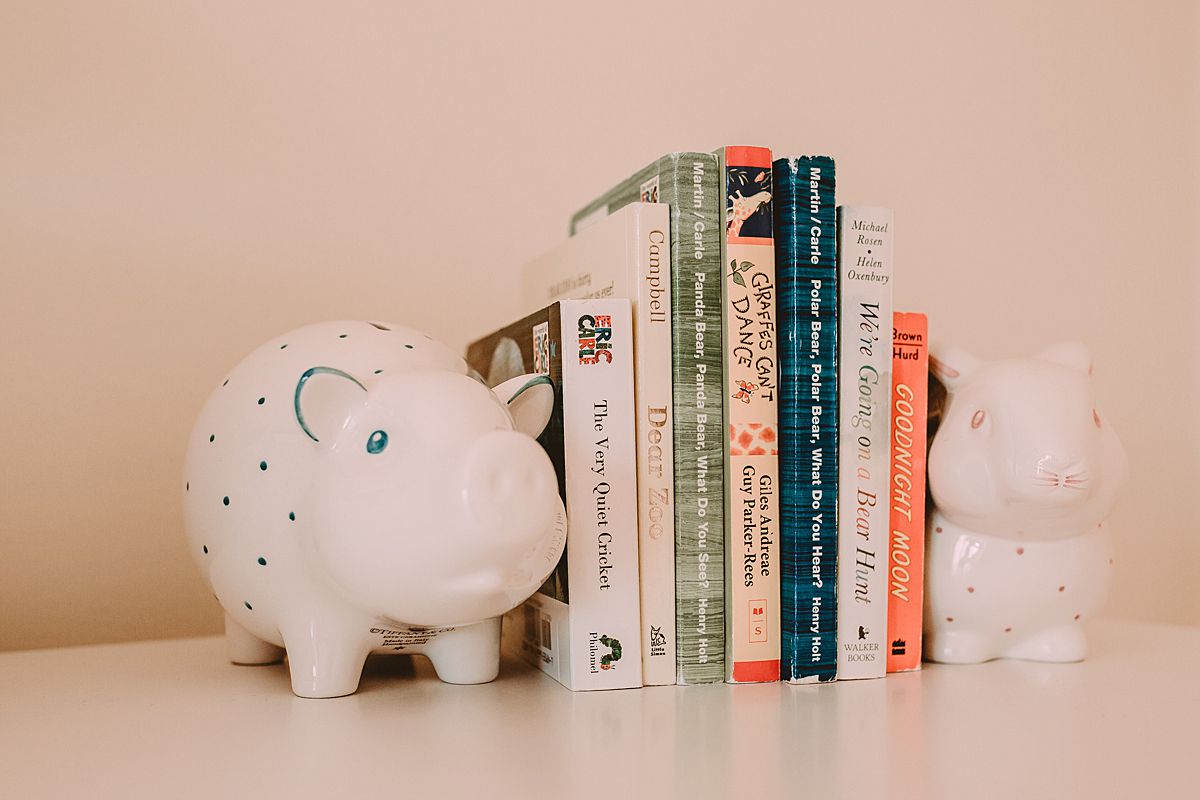 newborn room details of children's books held upright by two pig bookends