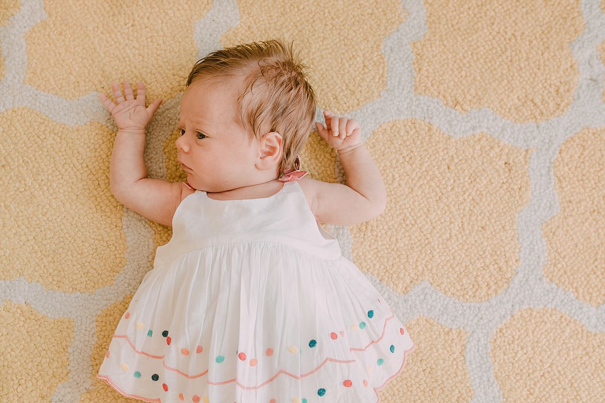 newborn baby girl lying on rug during nyc newborn session. Image by krystil mcdowall