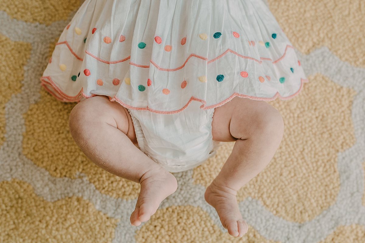 newborn baby girl lying on rug during nyc newborn session and close up of baby feet. Image by krystil mcdowall photography