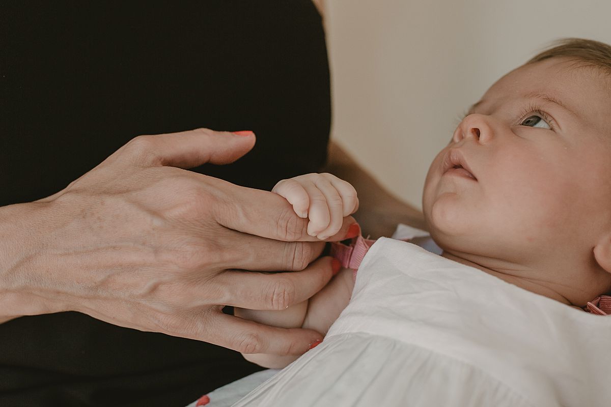 close up of mom holding newborn daughter's hand. image by krystil mcdowall photography