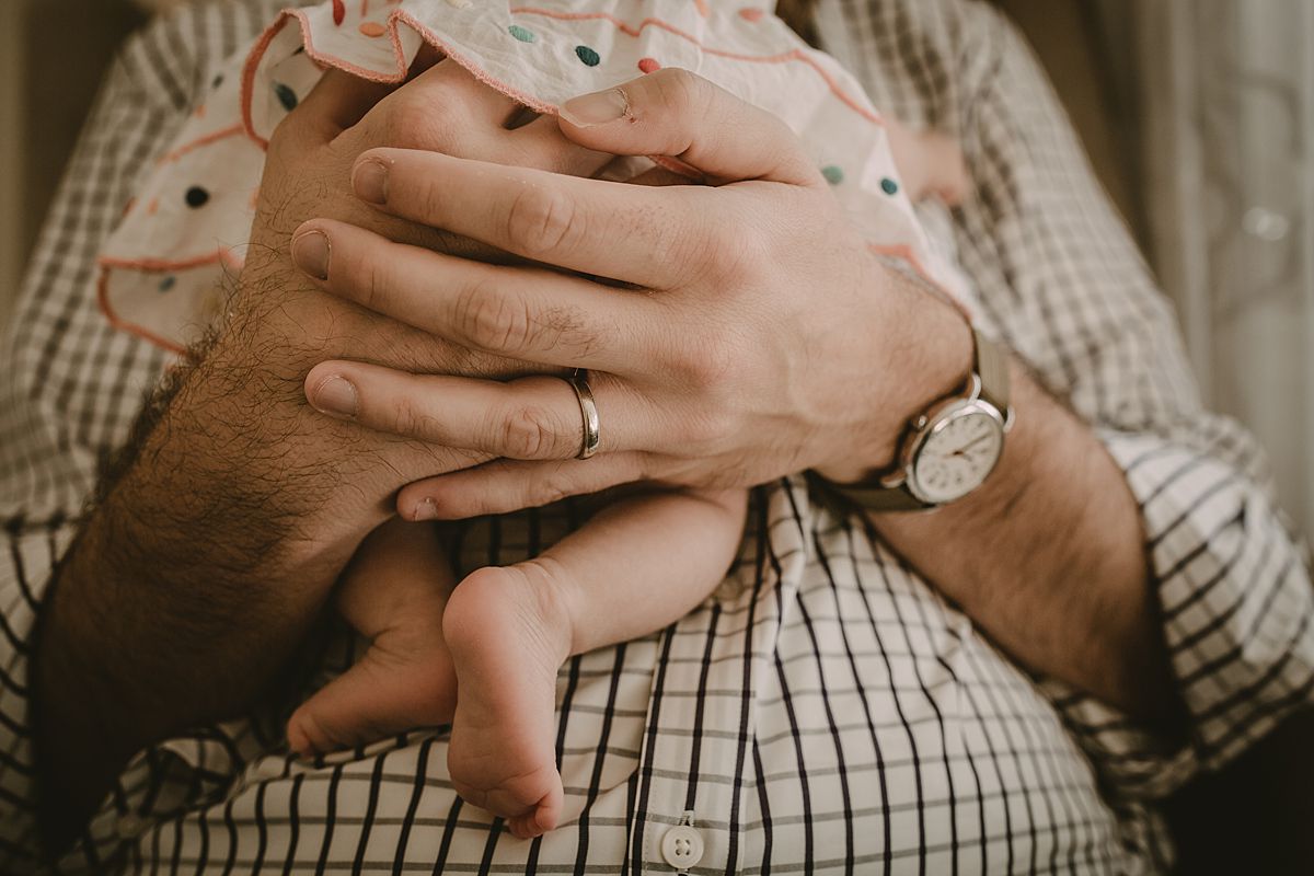 close up of dad holding newborn baby girl's feet. Image by krystil mcdowall photography