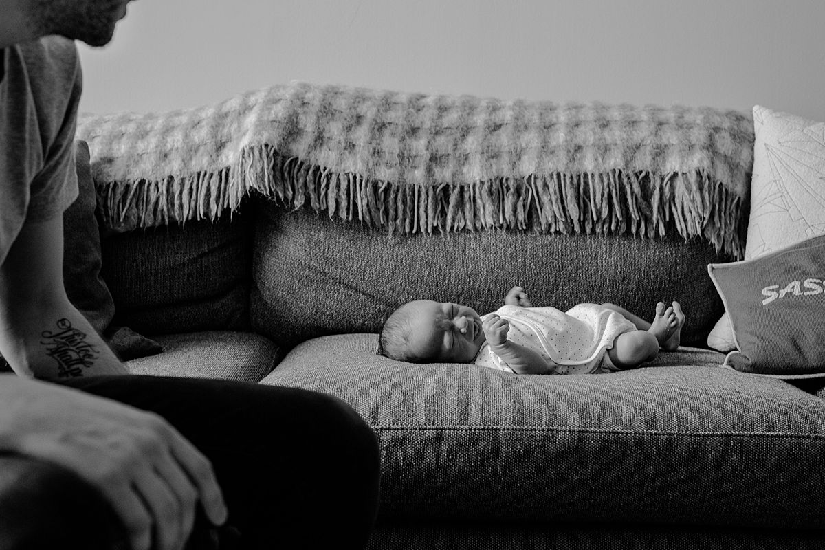 newborn boy scrunches his nose while laying on couch in nyc family newborn session in downtown manhattan
