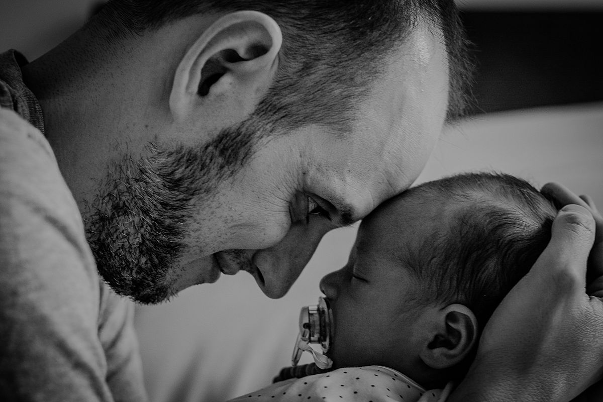 close up black and white image of dad holding newborn son with foreheads touching. photo by nyc family and newborn photographer krystil mcdowall