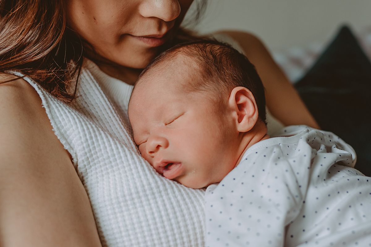 image of newborn son sleeping on mom's chest in living room of downtown nyc apartment in lifestyle session. image by krystil mcdowall