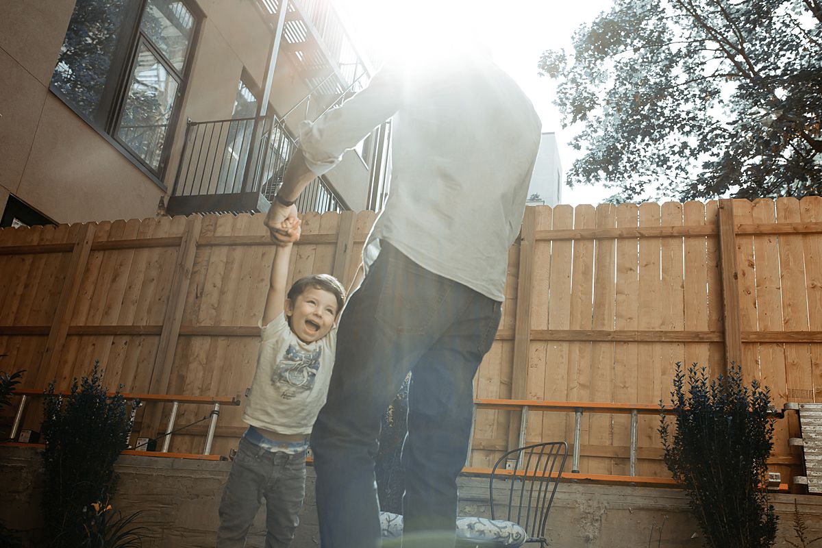 young boy gets swung around by dad having lots of fun in the sun. photo by krystil mcdowall photography