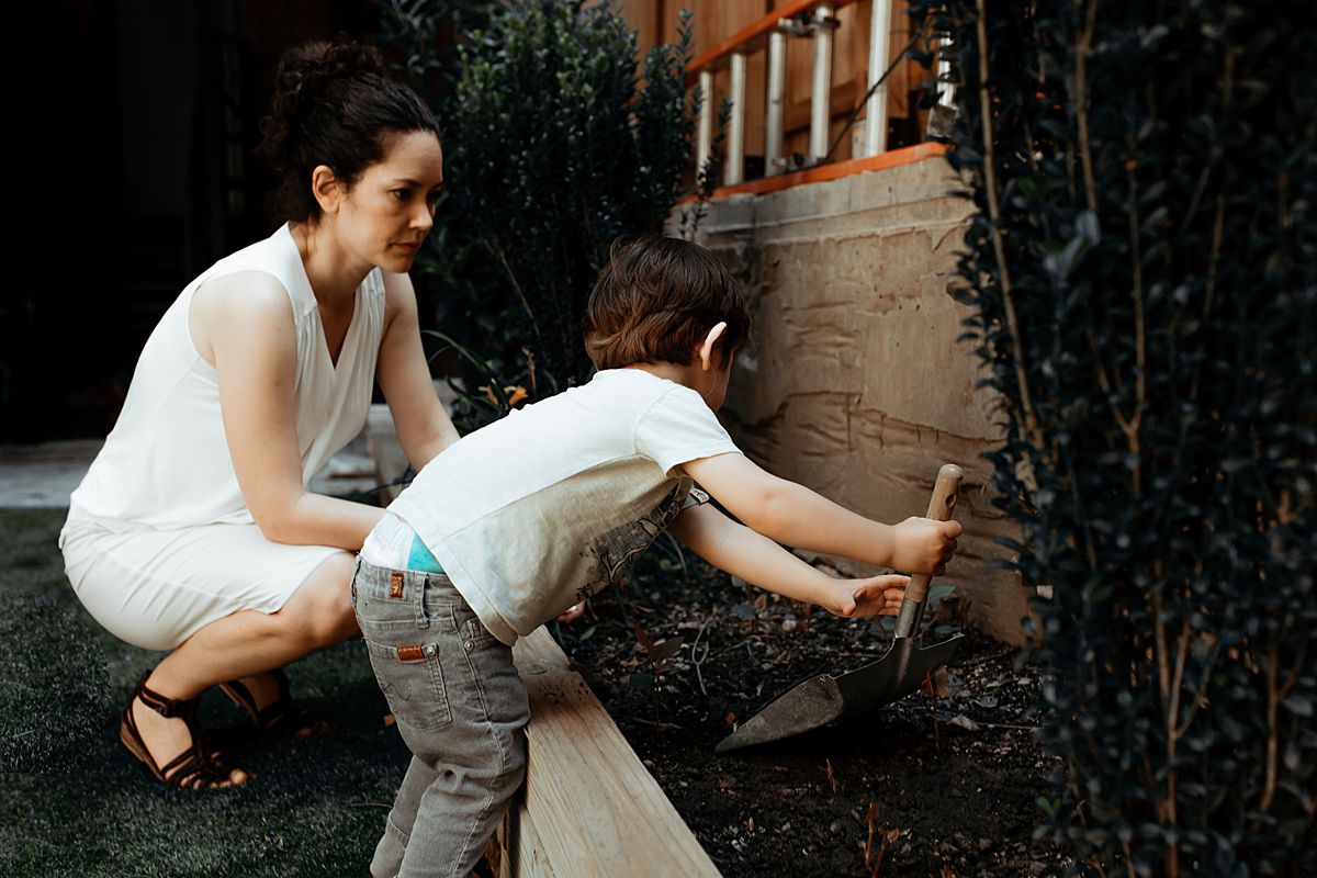 mom and son play in the garden outback during documentary family session. photo by nyc family and newborn photographer krystil mcdowall
